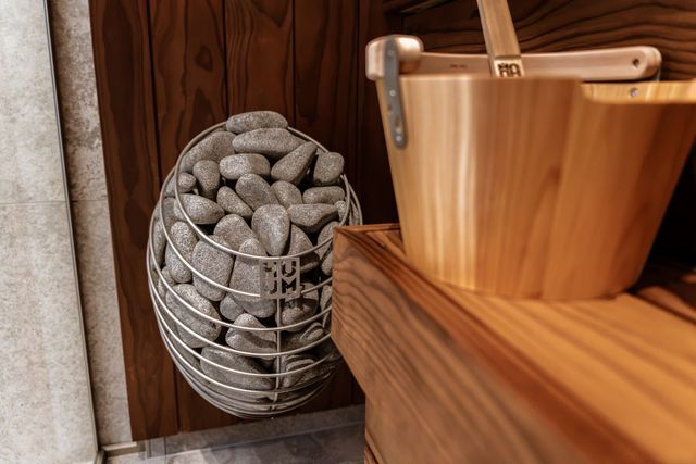 HUUM electric sauna heater with wooden cladding and sauna bench.